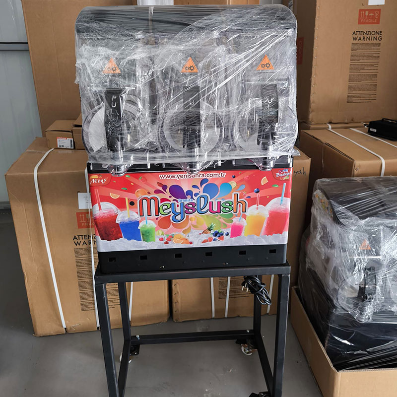 Kafe tezgahında çalışan kırmızı meyveli ice slush içecek makinesi.